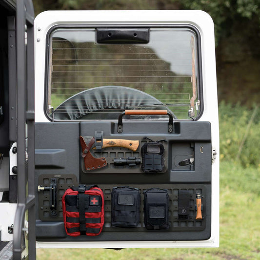 Back of a Defender 110 vehicle with molle storage organiser and equipment mounted on