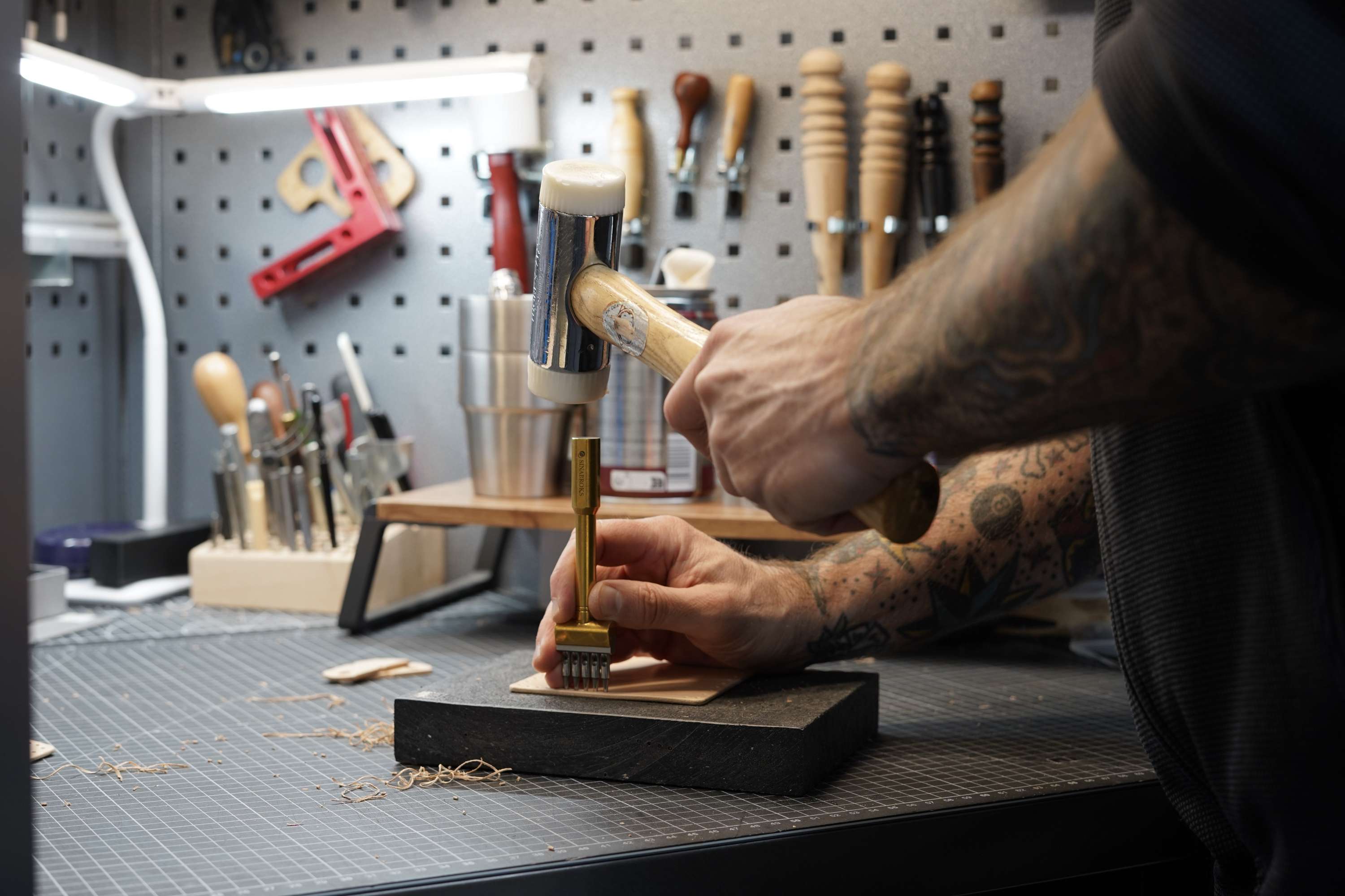 Person working with tools on a workbench in a workshop setting
