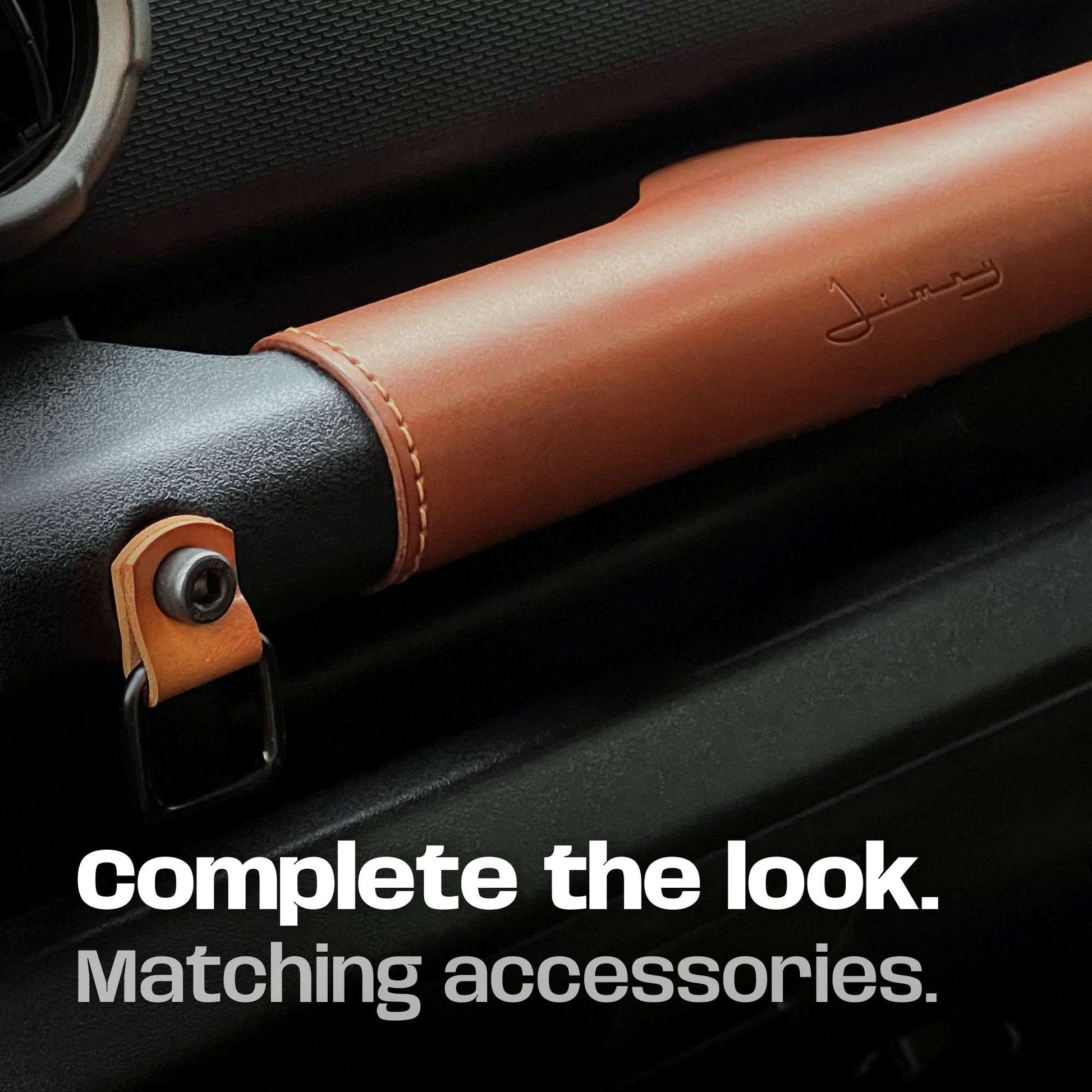 Tan leather cover fitted to suzuki jimny grab handle with matching leather utility hook.